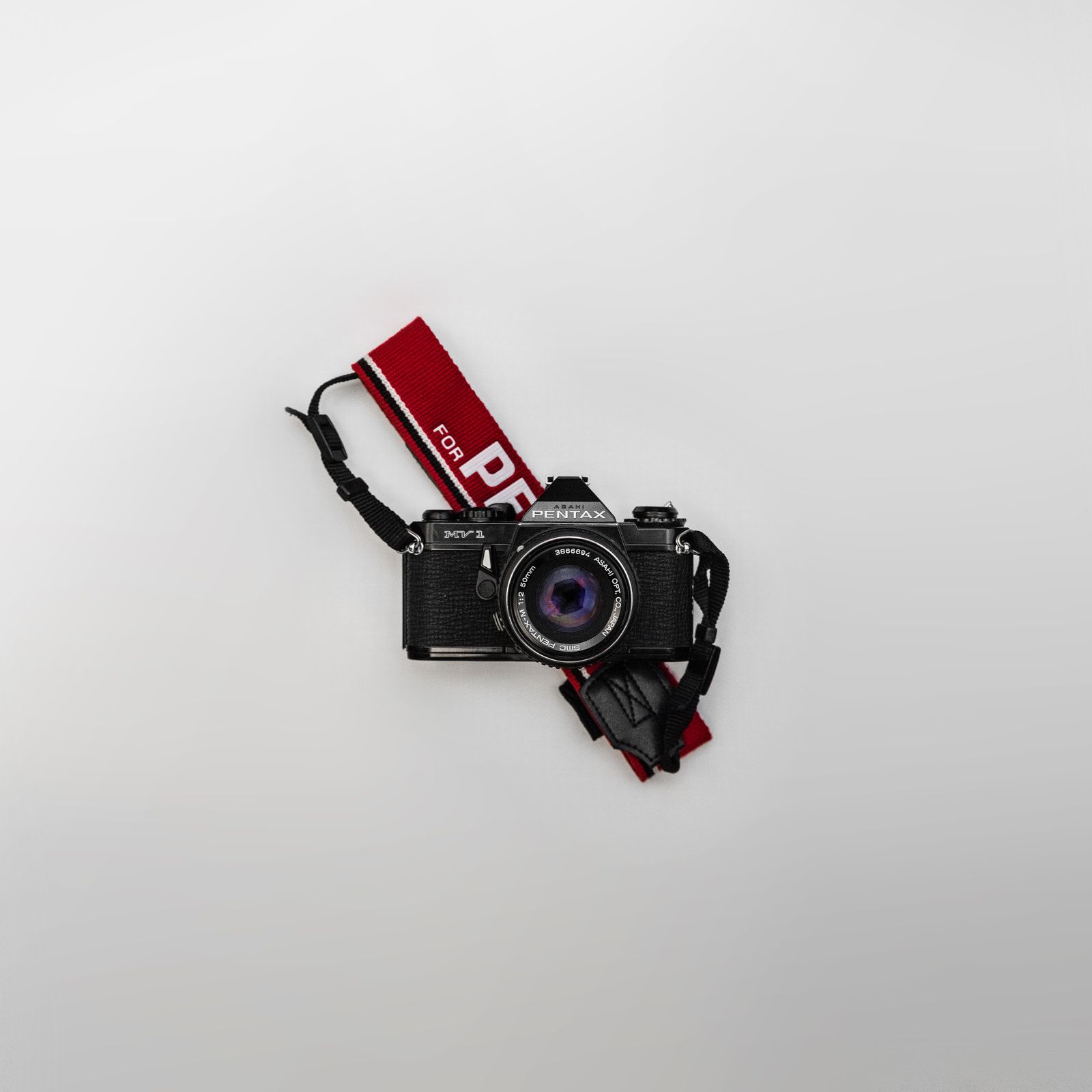 Film camera with a woven camera strap